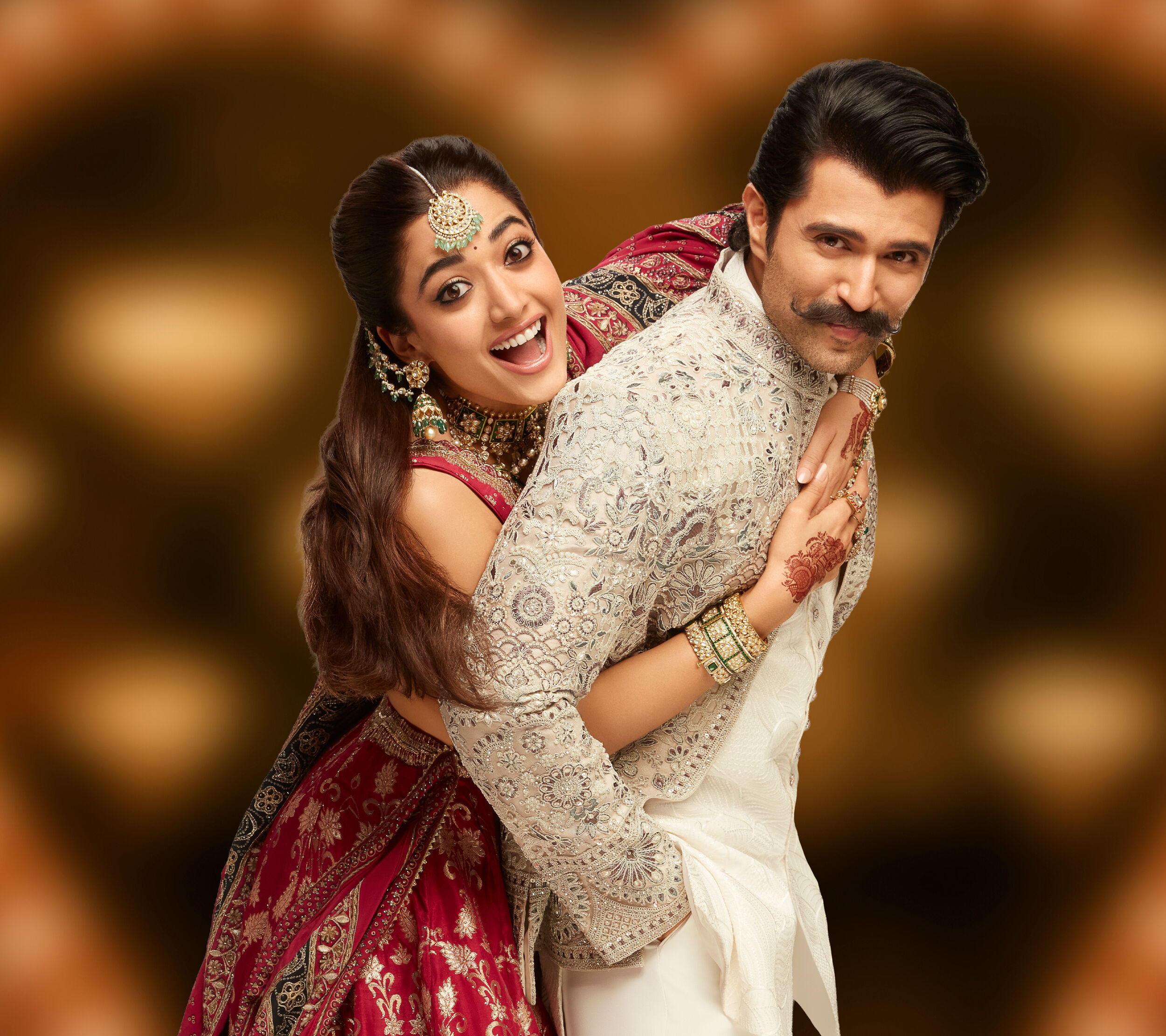 Vijay Deverakonda and Rashmika Mandanna sharing a joyful Virosh-inspired wedding moment, dressed in elegant Manyavar and Mohey ensembles.